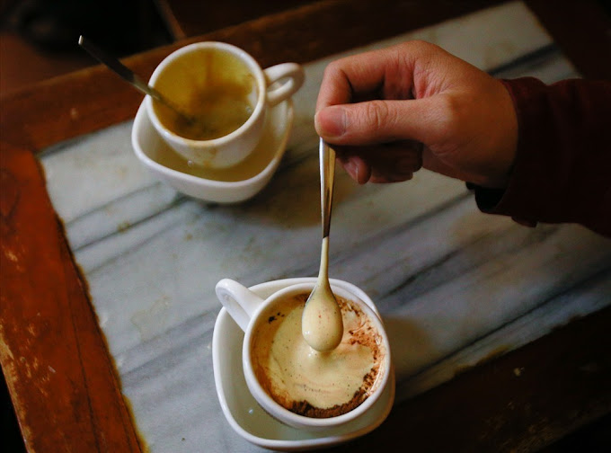 a hand holding a cup of coffee