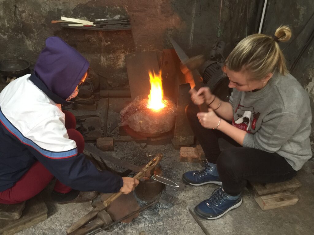 a little boy that is standing in front of a fire