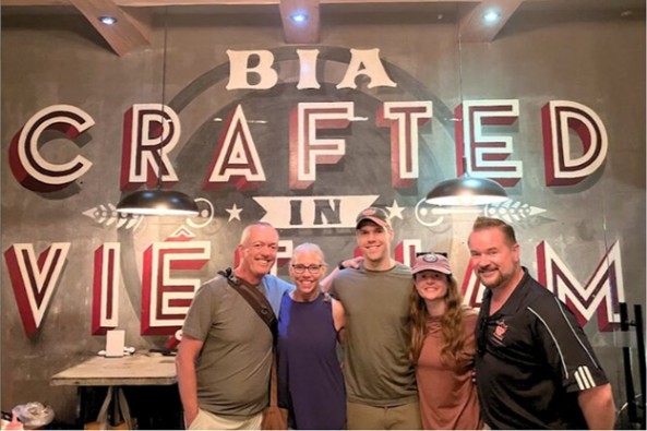 Five people standing together in front of a 'Crafted in Vietnam' sign.