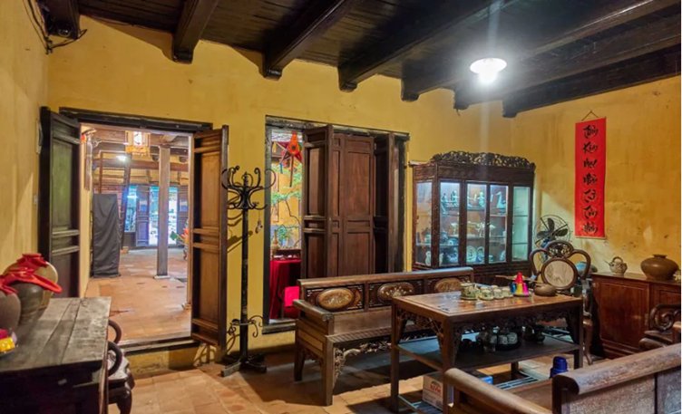 Traditional room with wooden furniture, display cabinet, and red wall scroll.