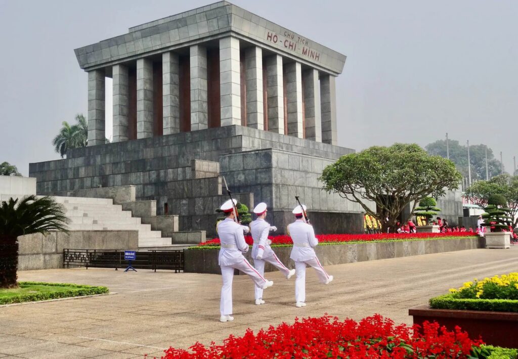 a group of people standing in front of Ho Chi Minh Mausoleum