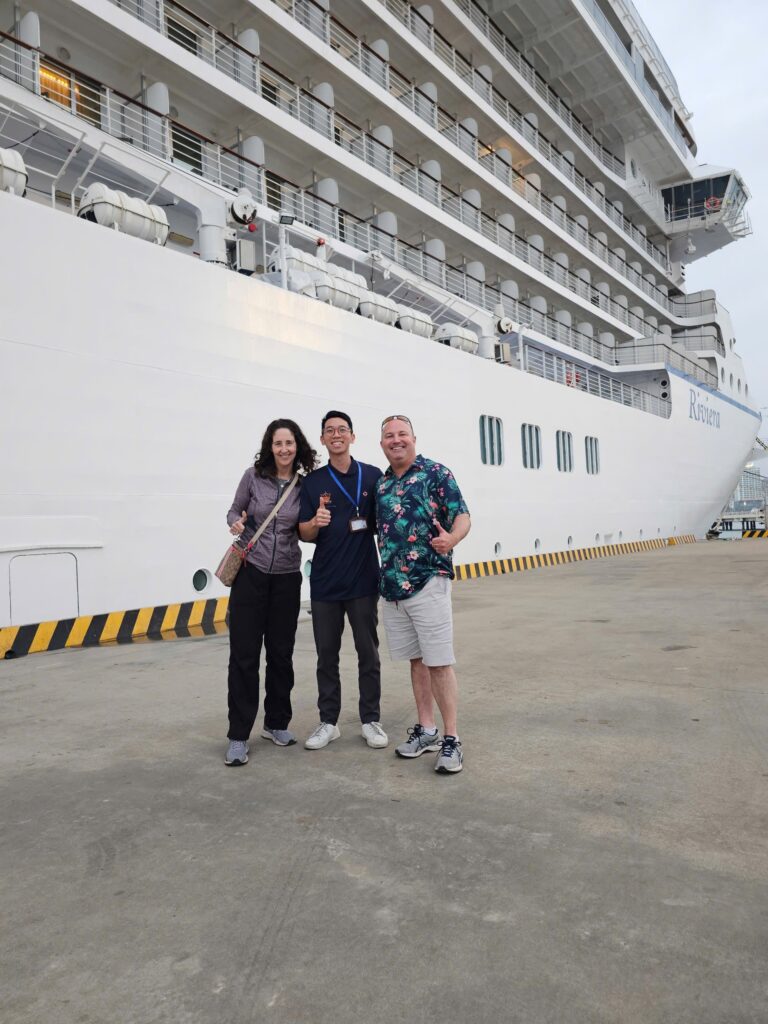 a group of people standing next to a ship