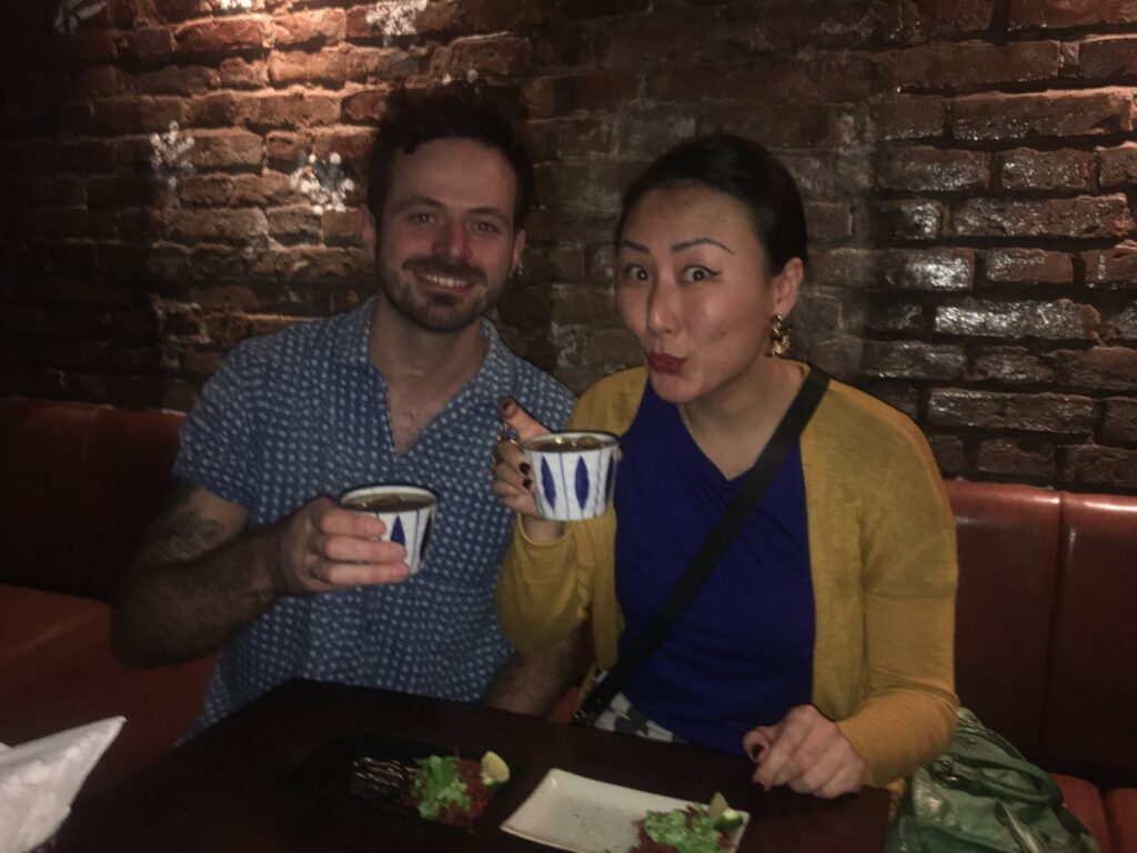 a man and woman sitting next to a brick wall