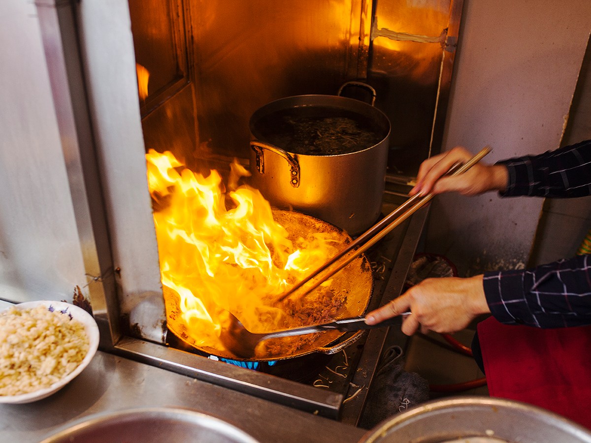 a person cooking food on a stove