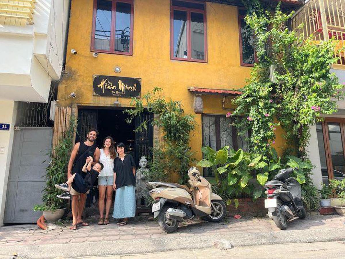 a group of people sitting on a bench in front of a building