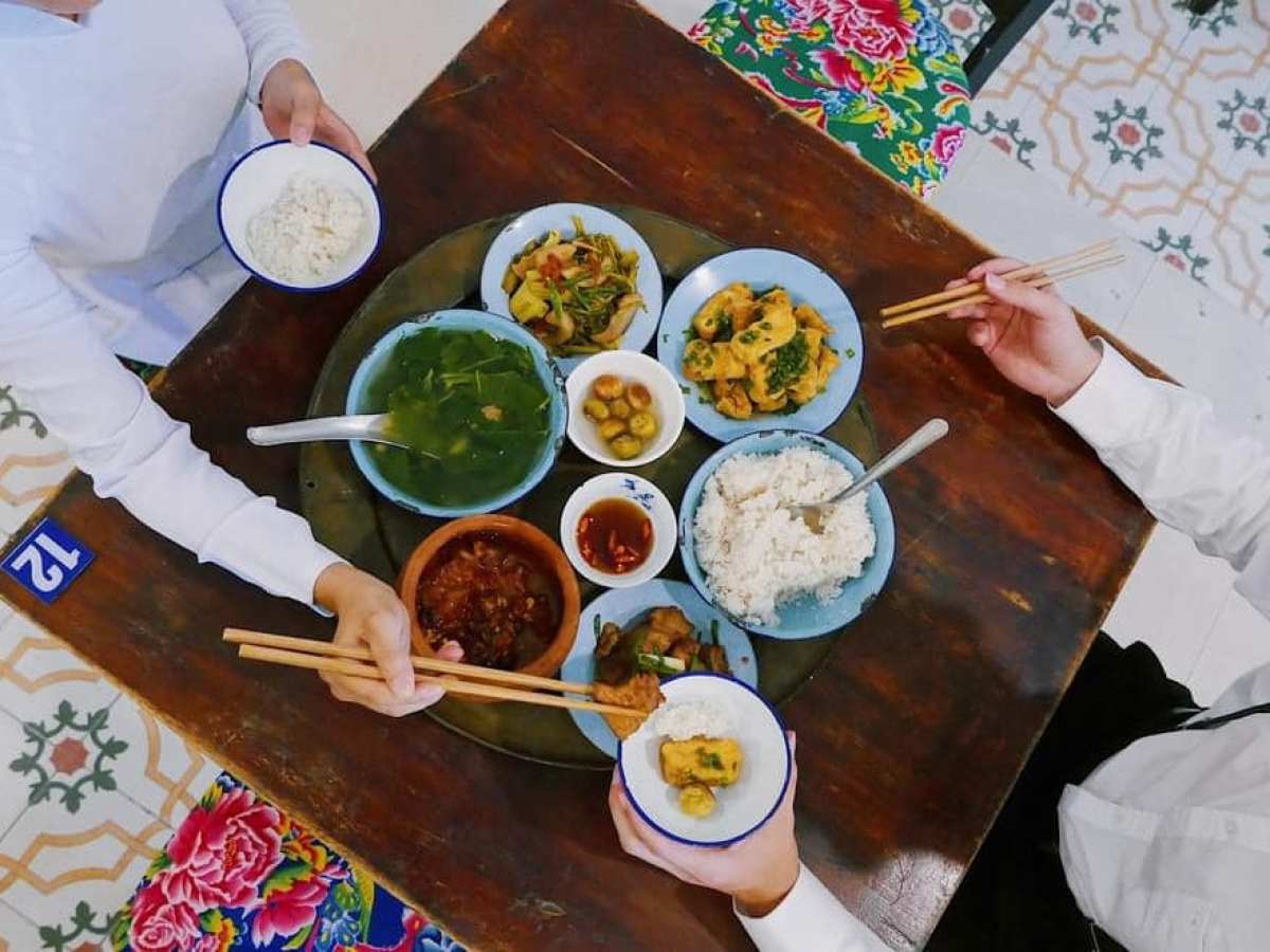 a person sitting at a table with a plate of food