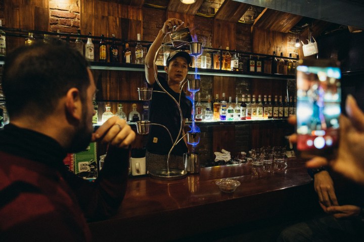 a man sitting at a table with wine glasses