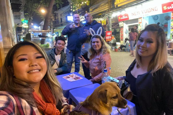 a woman holding a dog posing for the camera