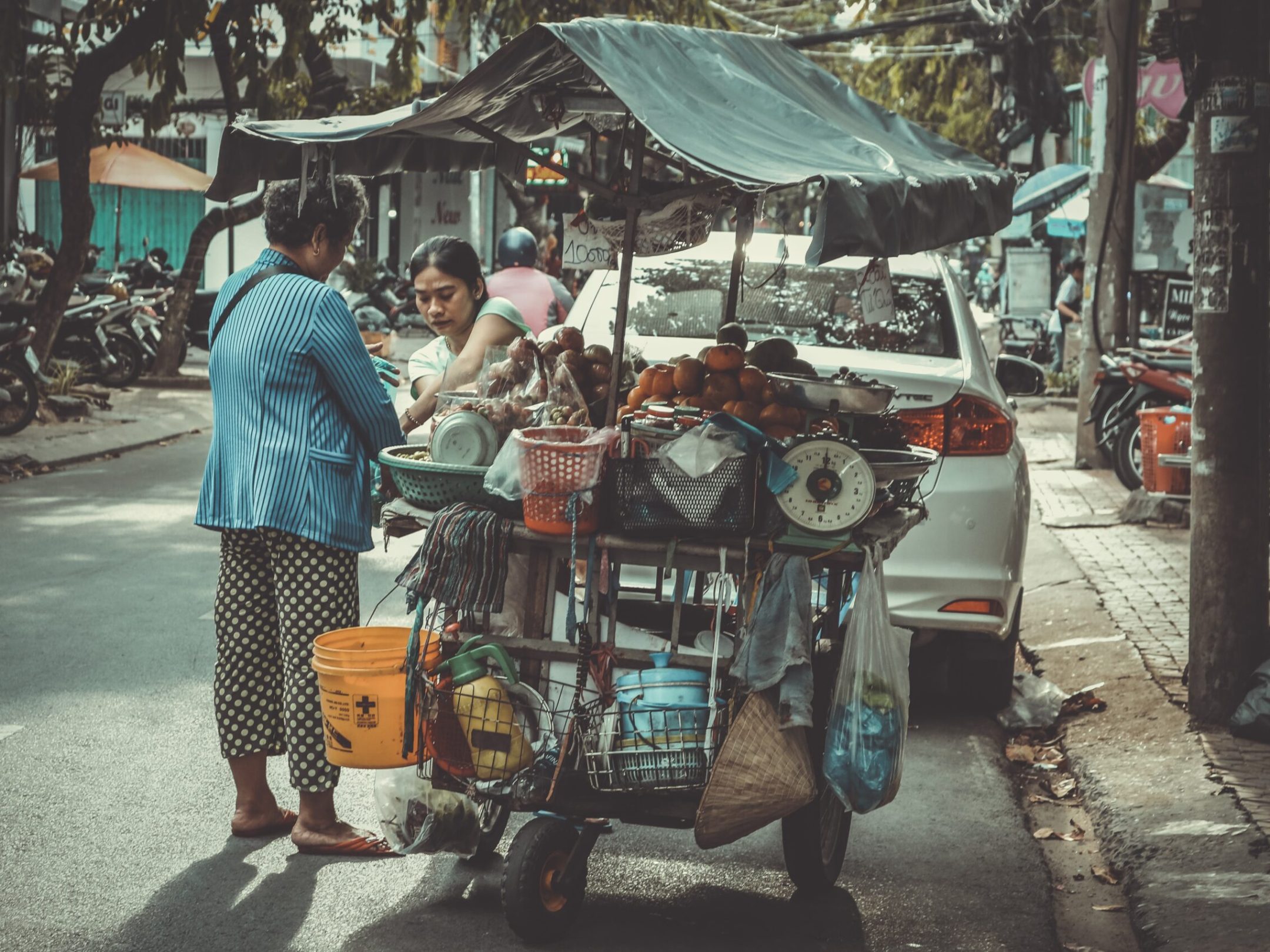 a group of people walking down a street holding an umbrella