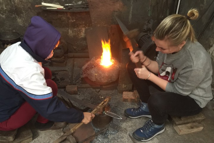 a little boy that is standing in front of a fire
