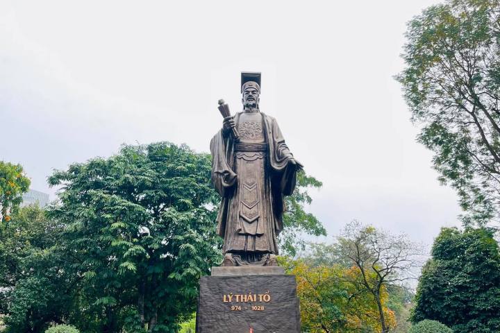 a clock tower in front of a statue