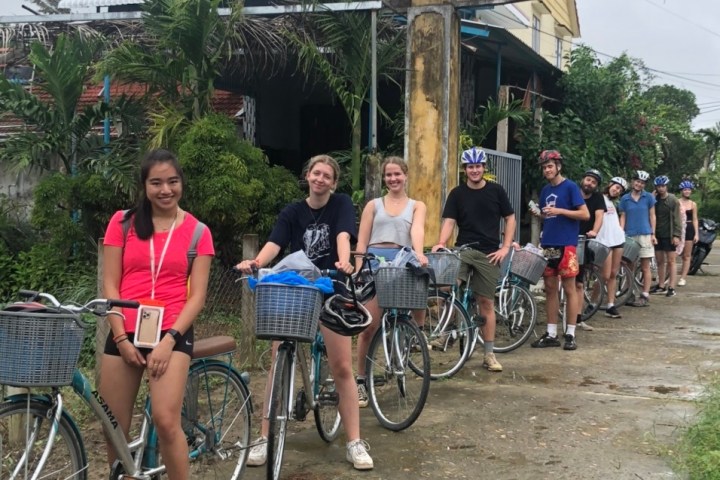 a group of people riding on the back of a bicycle