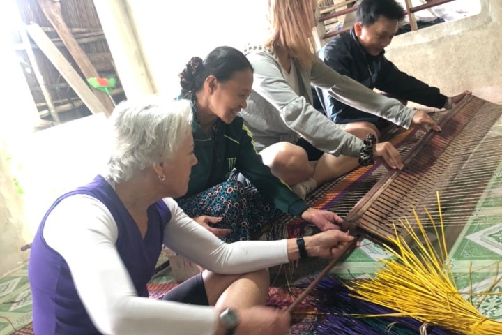 a group of people sitting at a table using a laptop