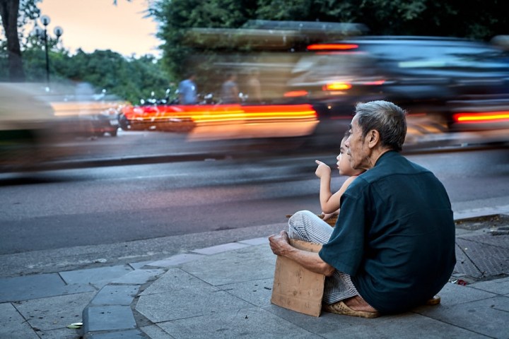 a man sitting on a sidewalk