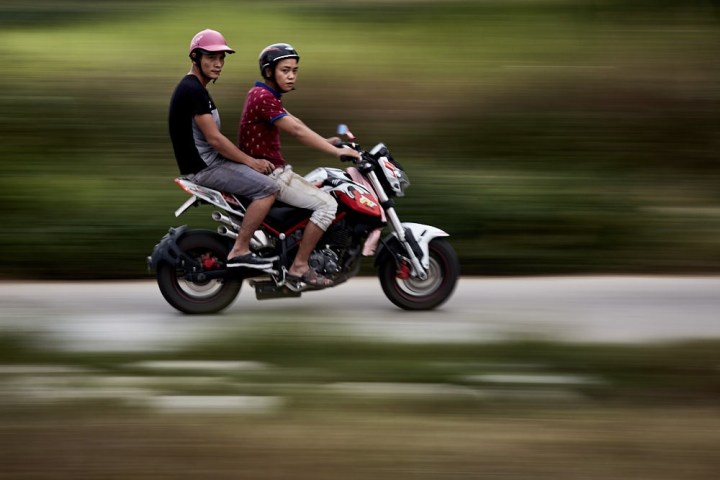 a man riding a motorcycle down a road