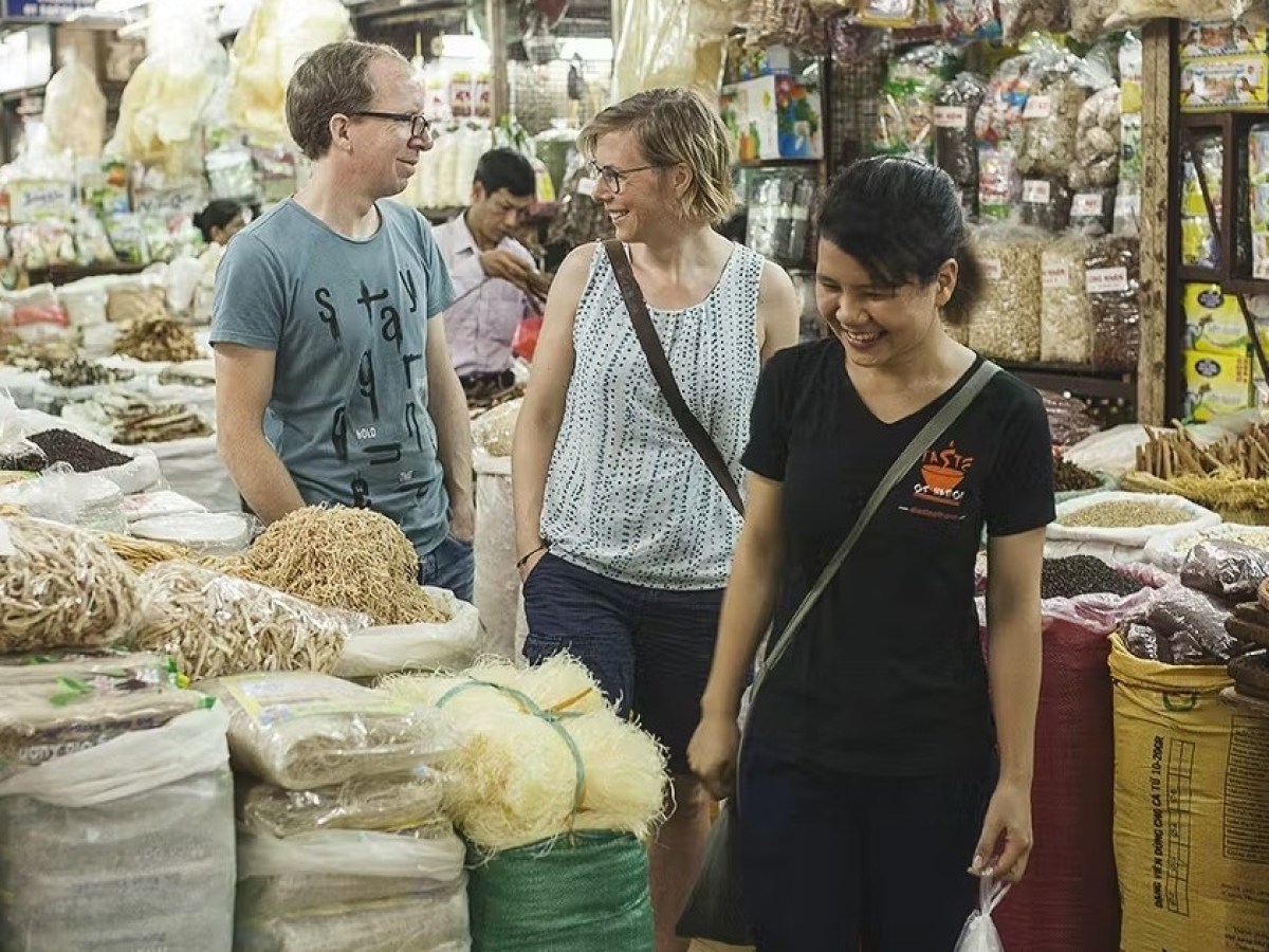 a person standing in front of a store filled with lots of fresh produce