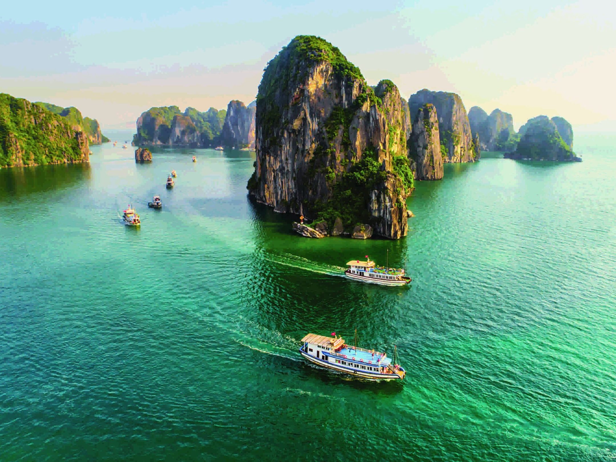 a small boat in a body of water with Ha Long Bay in the background