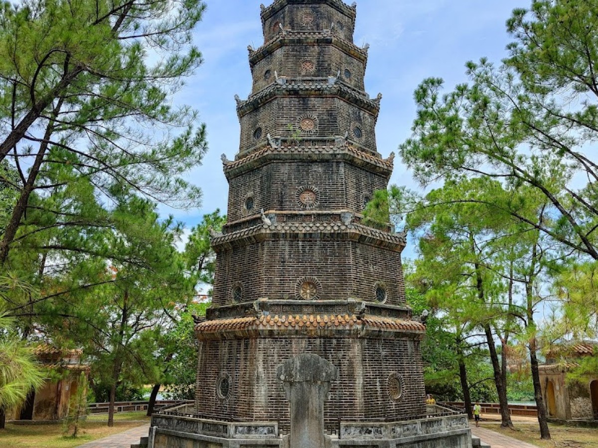 a tall clock tower sitting under a tree