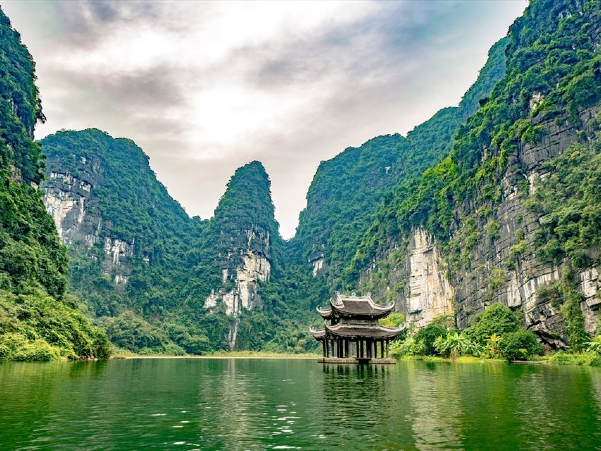 a small boat in a body of water with a mountain in the background