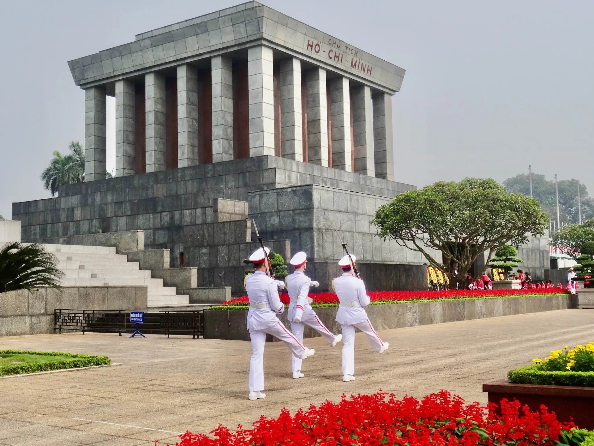 a group of people standing in front of Ho Chi Minh Mausoleum