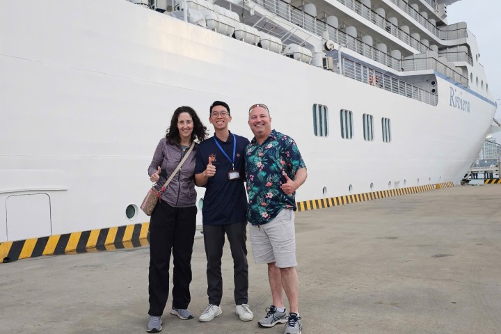 a group of people standing next to a ship