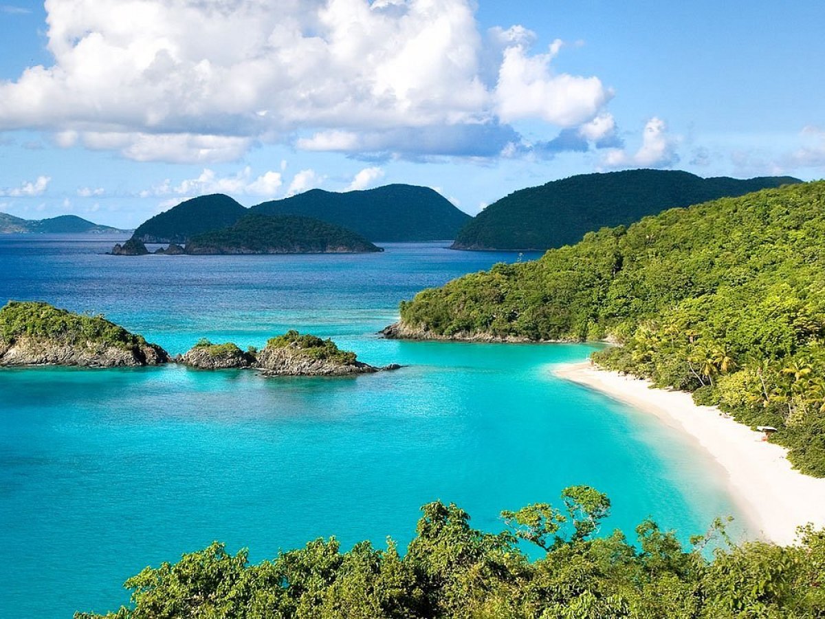 an island in the middle of a body of water with Virgin Islands National Park in the background