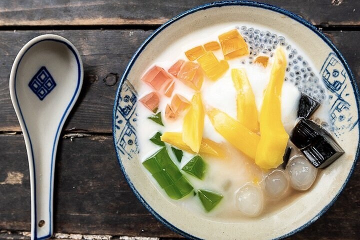 Colorful dessert with fruit and jelly in a bowl, spoon on the side.