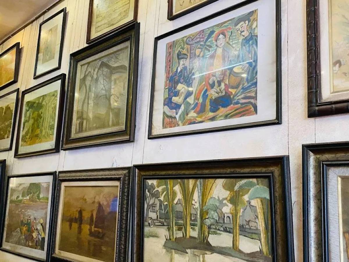 Wall of framed paintings and artwork in various styles and sizes.