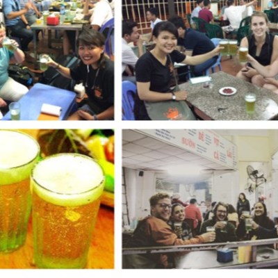Groups of people enjoying drinks at tables, with two glasses of beer prominently displayed.