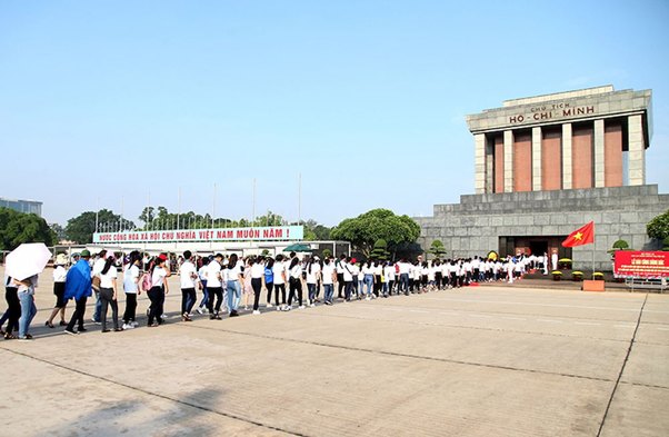 Visitors line up outside Ho Chi Minh Mausoleum on a sunny day.