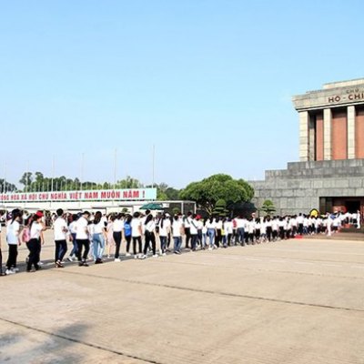 Visitors line up outside Ho Chi Minh Mausoleum on a sunny day.