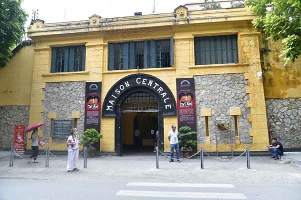 Front view of historic building 'Maison Centrale' with several people outside.