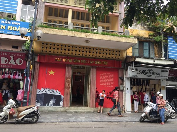 Street scene with shops and scooters, featuring a red storefront with a large star symbol.