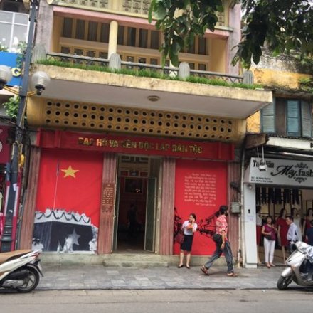 Street scene with shops and scooters, featuring a red storefront with a large star symbol.