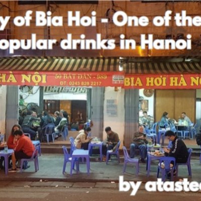 Outdoor bia hoi restaurant in Hanoi with people seated at plastic tables and chairs, illuminated at night.