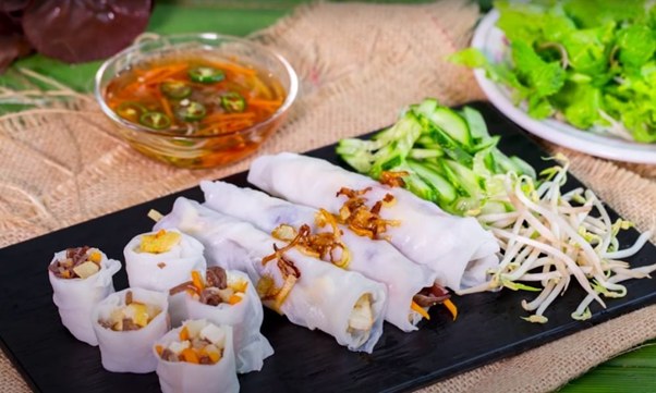 Vietnamese rice rolls with vegetables, sprouts, and dipping sauce.