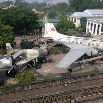 Aerial view of military aircraft displayed outdoors in a museum courtyard.