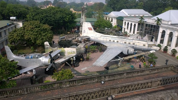 Aerial view of military aircraft displayed outdoors in a museum courtyard.