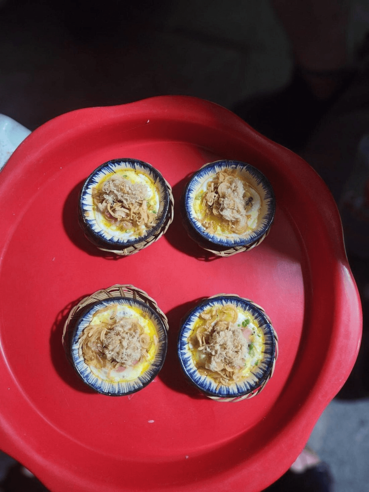 Four small tarts with toppings on a red tray.